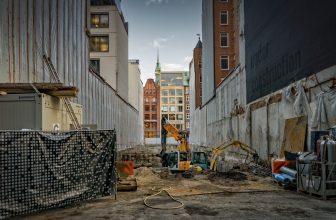 Rue en chantier, bâtiment en construction et peleteuse